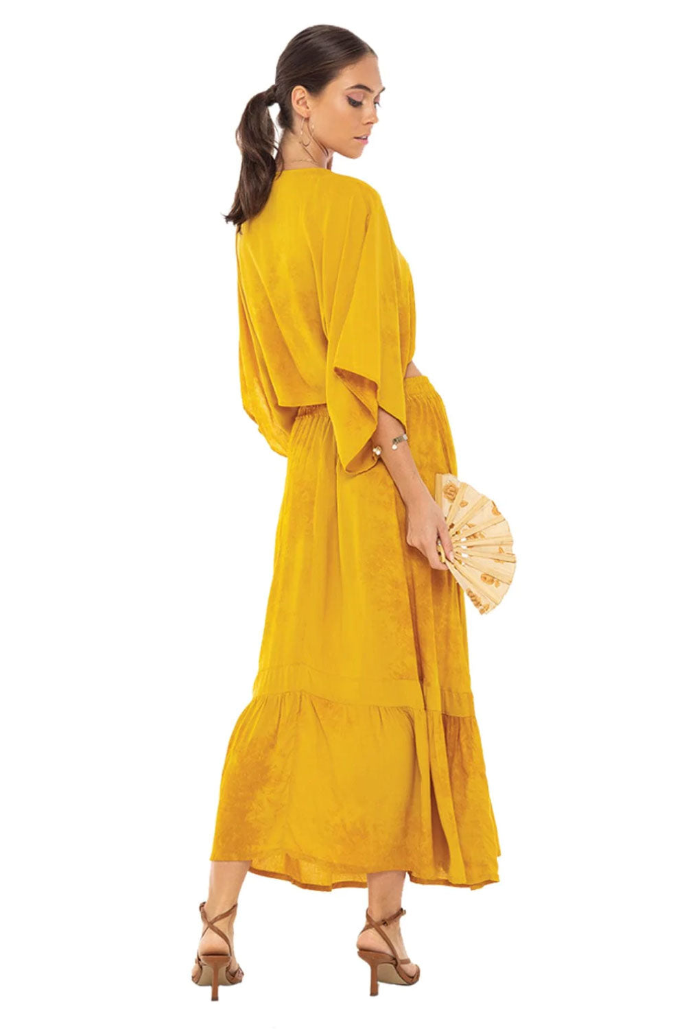 Image of the back of Khush Clothing's Sakura Midi Two-Piece Set, in Slosh Mustard, on a model.
