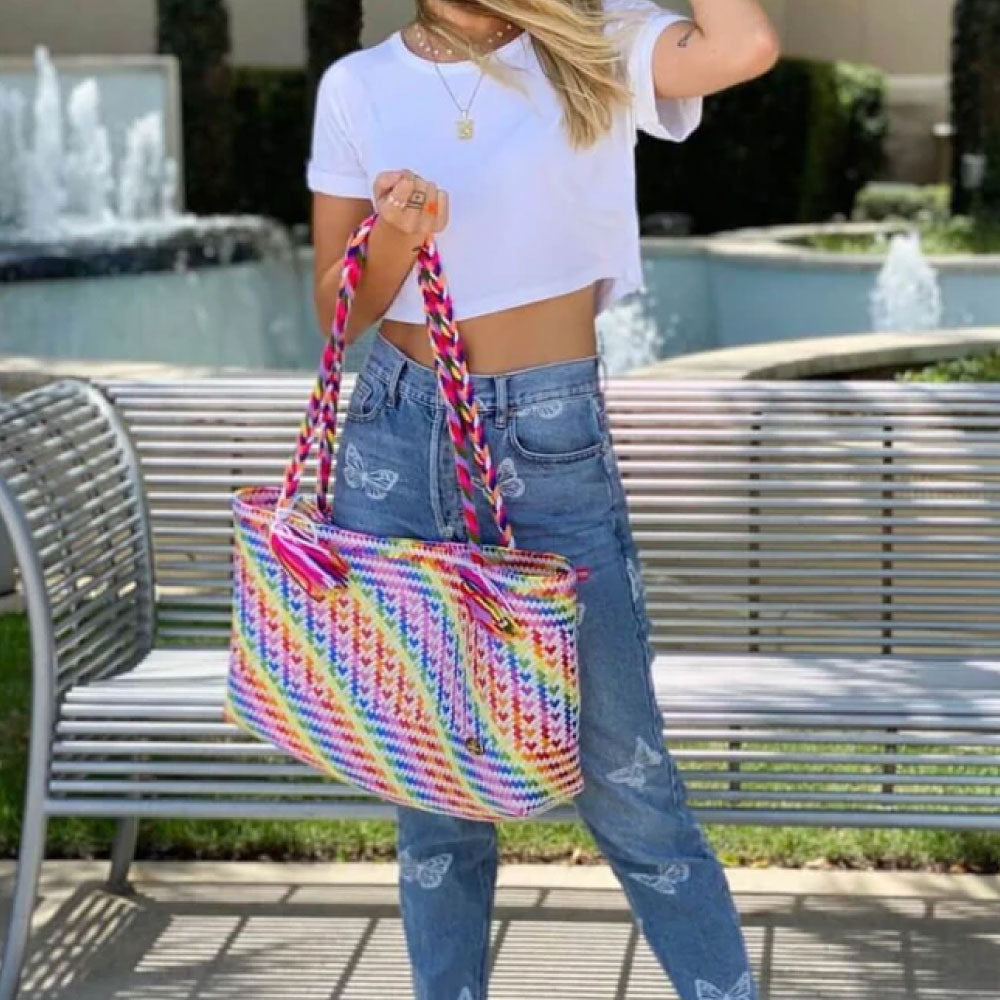 Image of a woman holding The Nicky Bag in White Rainbow Hearts.