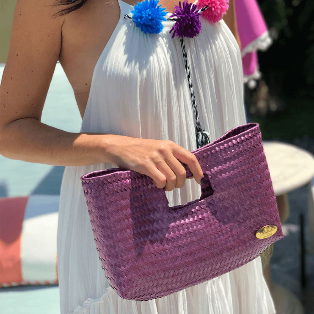 Image of woman holding Alison Woven Clutch in Purple.