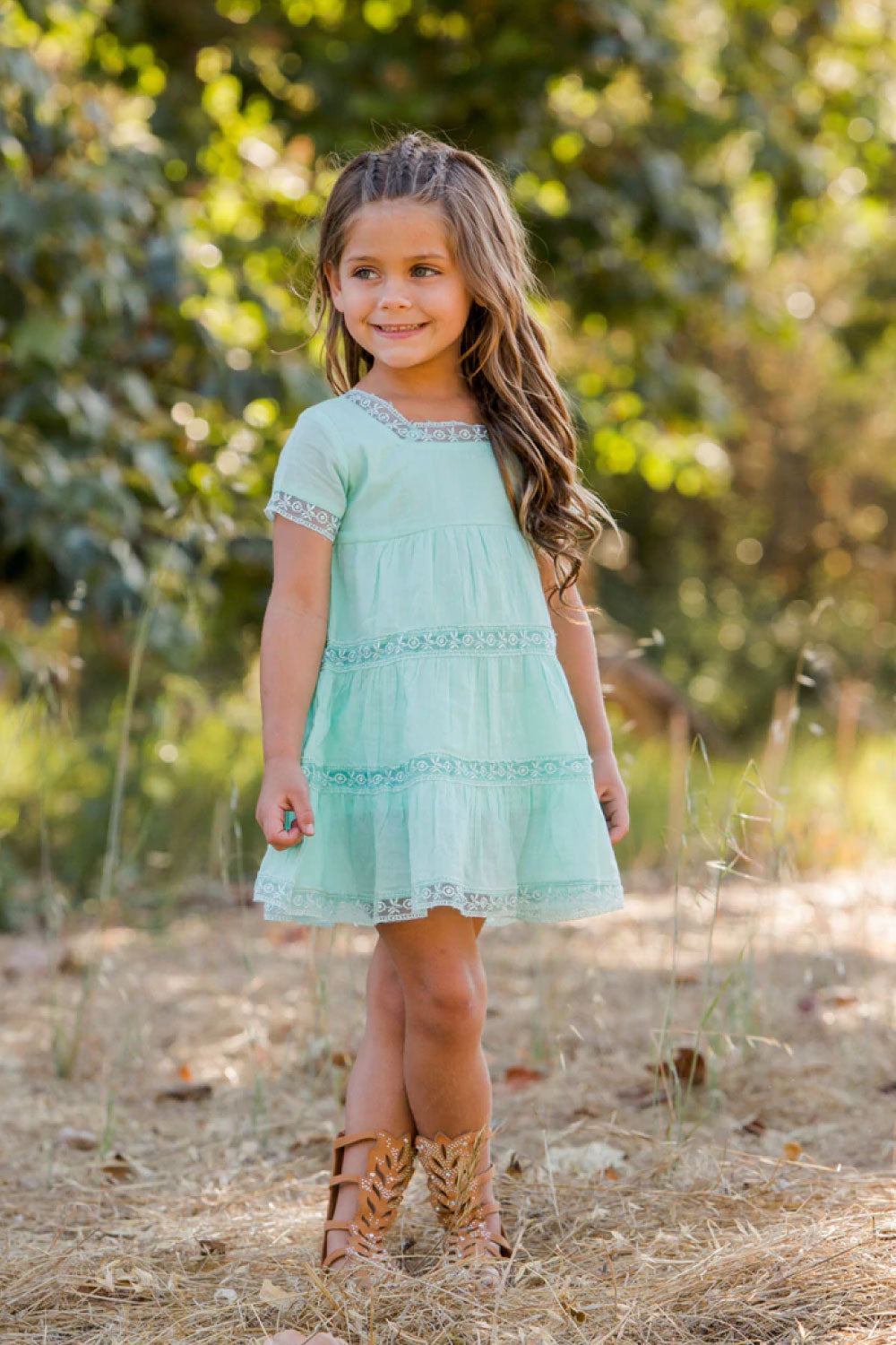 Image of a child wearing the Athena Dress.
