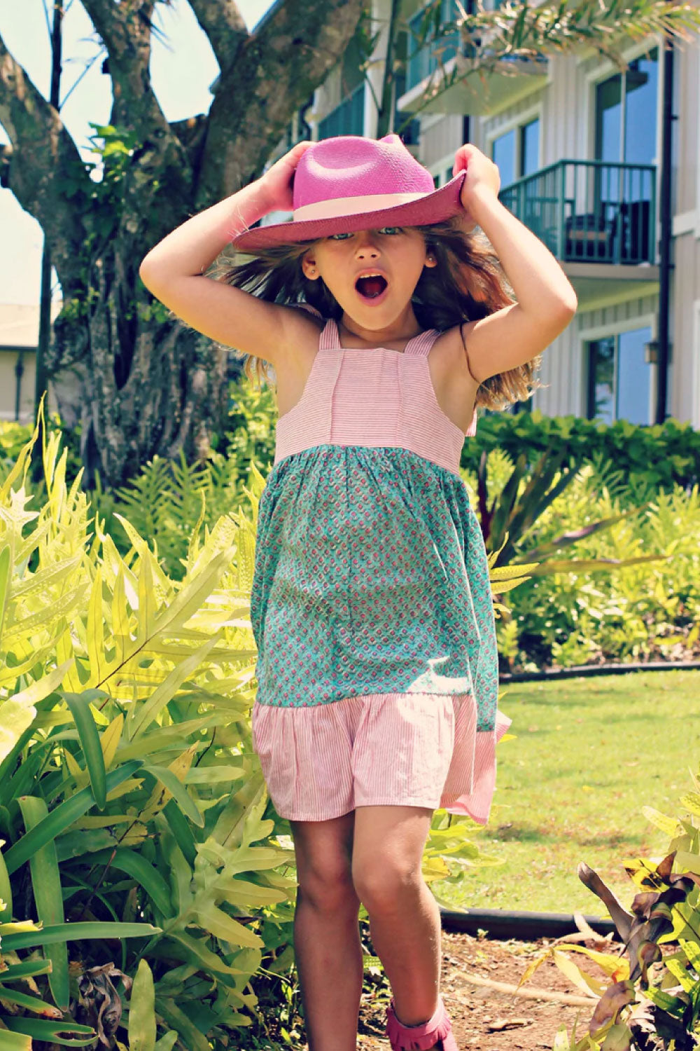 Image of a child wearing the Misha Dress in Green.